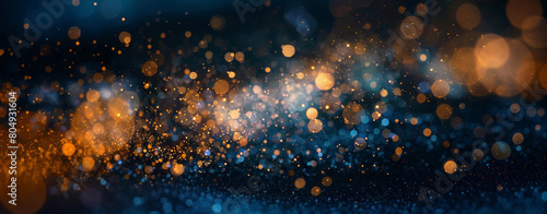 Abstract background of golden and blue bokeh lights, creating a dreamlike atmosphere of twinkling particles.