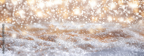 Abstract golden sparkling bokeh lights on snow surface, perfect for festive backgrounds.