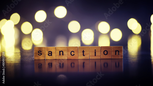 word sanctions spelled in letters on table made of wooden block letters with dramatic lighting and smoke photo