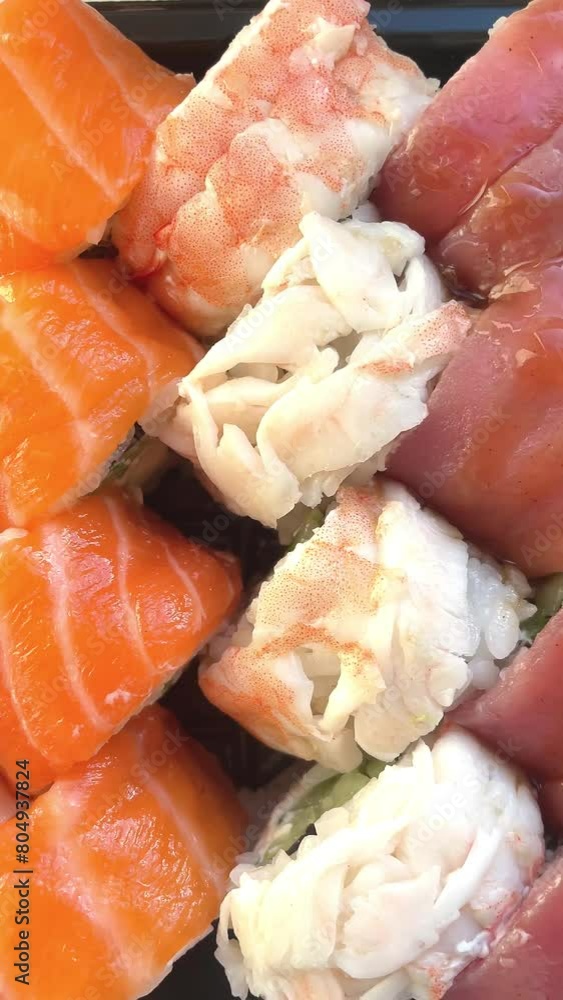 Sushi roll set, rolls with salmon, tuna, eel, shrimp, sesame, closeup, sushi japanese food, seafood, advertising sushi rolls, top view, sushi macro Sushi roll set, rolls with salmon, tuna, eel, shrimp, sesame, closeup, sushi japanese food, seafood, advertising sushi rolls, top view, sushi macro