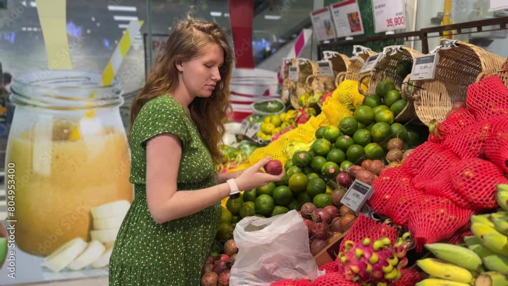 pregnant woman chooses tropical fruits in the supermarket pregnant woman chooses tropical fruits in the supermarket