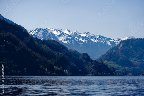 Rural landscape in the Swiss Alps seen from passenger ship running on Lake Lucerne between Kehrsiten and City of Lucerne on a sunny spring day. Photo taken April 11th, Lake Lucerne, Switzerland.