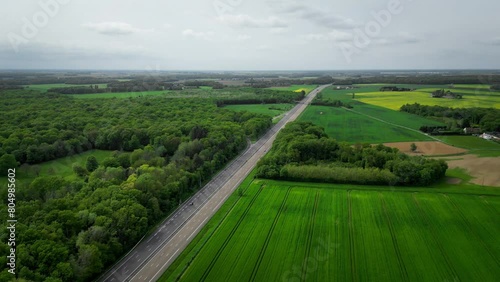 European highway seen from the sky, quiet traffic, in the middle of fields and forests, aerial shooting by drone in France near Paris.