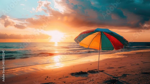 Hello Summer text on a colorful beach umbrella during a vibrant sunset