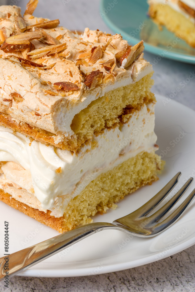 Norwegian cake. With meringue, whipped cream and almonds. Light background Norwegian cake. With meringue, whipped cream and almonds. Light background