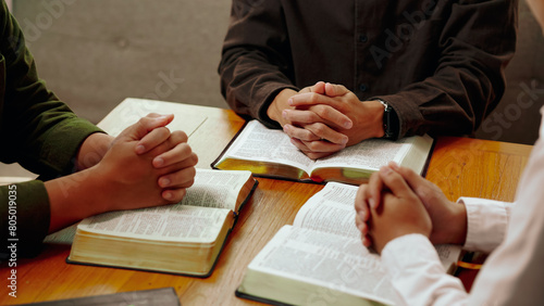 Christian Bible Study Concepts. Christian group or family prayer together with a holy bible on a wooden table in church for worship to god in the morning. people pray with faith, Spirituality.