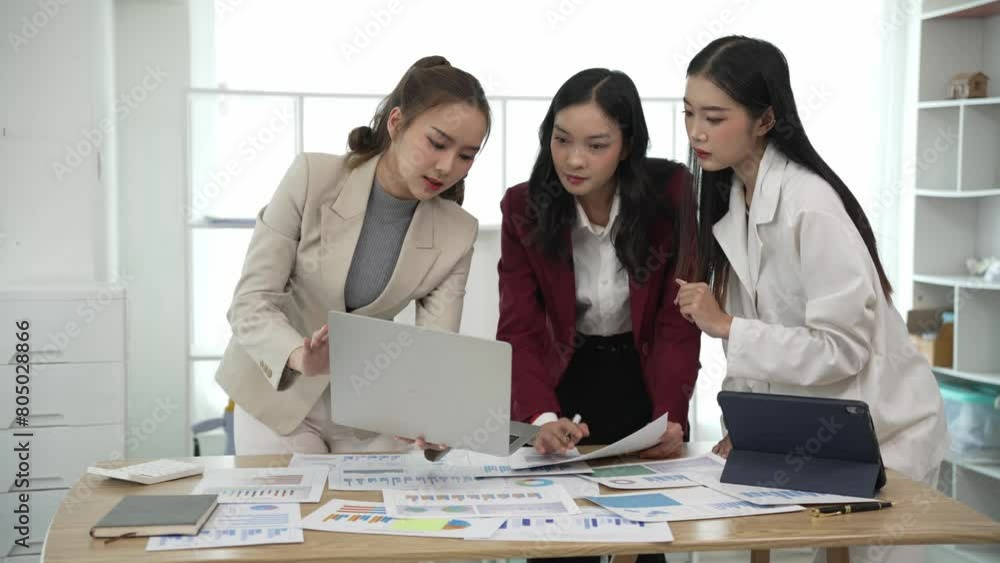 Smiling Asian businesswoman talking with colleagues and exchanging ideas together at office using laptop with female consultant laughing in conference room collaborating, new business idea Smiling Asian businesswoman talking with colleagues and exchanging ideas together at office using laptop with female consultant laughing in conference room collaborating, new business idea