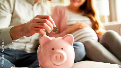 Expecting couple saving money in piggy bank