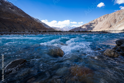 Vibrant view of the Indus River flowing through a barren Himalayan valley under a clear blue sky in Ladakh  India.