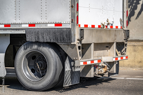 Rear axle wheel with tire and automatic inflation and cleaning brush on the dry van semi trailer running on the road