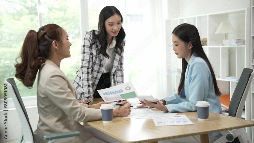 Smiling Asian businesswoman talking with colleagues and exchanging ideas together at office using laptop with female consultant laughing in conference room collaborating, new business idea Smiling Asian businesswoman talking with colleagues and exchanging ideas together at office using laptop with female consultant laughing in conference room collaborating, new business idea