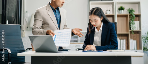Furious two Asian businesspeople arguing strongly after making a mistake at work in modern office