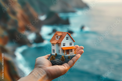 photo with ample copy space to convey the message, a real estate agent's hand proudly displays a miniature model of a dream house, against a background symbolizing the journey of b