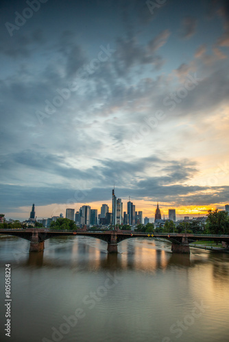 View from a bridge over the River Main to a skyline in the financial district in the background as the sun sets. Twilight in Frankfurt am Main  Hesse Germany