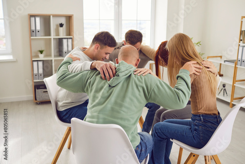 Diverse group of people is embracing in a circle during a psychotherapy session. They show support, unity, and togetherness, forming a close knit team or community seeking help and support together.