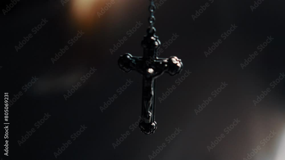 Rosary beads swinging and hanging in dark room Rosary beads swinging and hanging in dark room