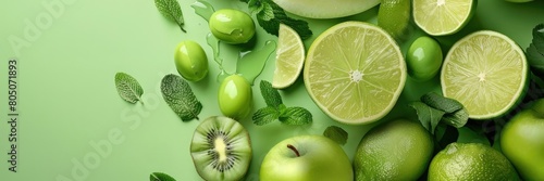 Vibrant Green Fruits and Mint Leaves Arrangement on Green Background photo
