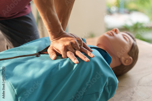 Tableau sur toile Close-up of middle-aged Asian male hands performing cardiopulmonary resuscitation (CPR) on a training dummy