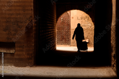 Donna araba che cammina con la spesa photo