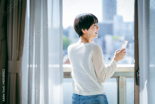 部屋でスマホを操作する女性 Free Download 部屋でスマホを操作する女性 - GFXLoad