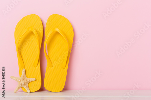 Bright yellow flip-flops on table. Summer concept © Liami