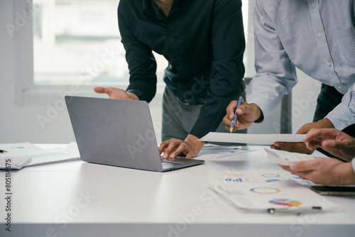 Foto Two men are working on a laptop in front of a white table