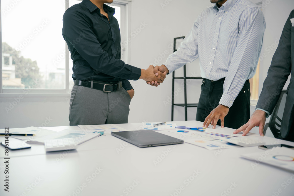 Three men shake hands in a business meeting Three men shake hands in a business meeting