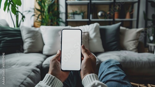 A person sitting on a sofa with a phone in his hand Looking at a blank white screen High resolution, high quality, soft lighting, bright colors, and studio photography.