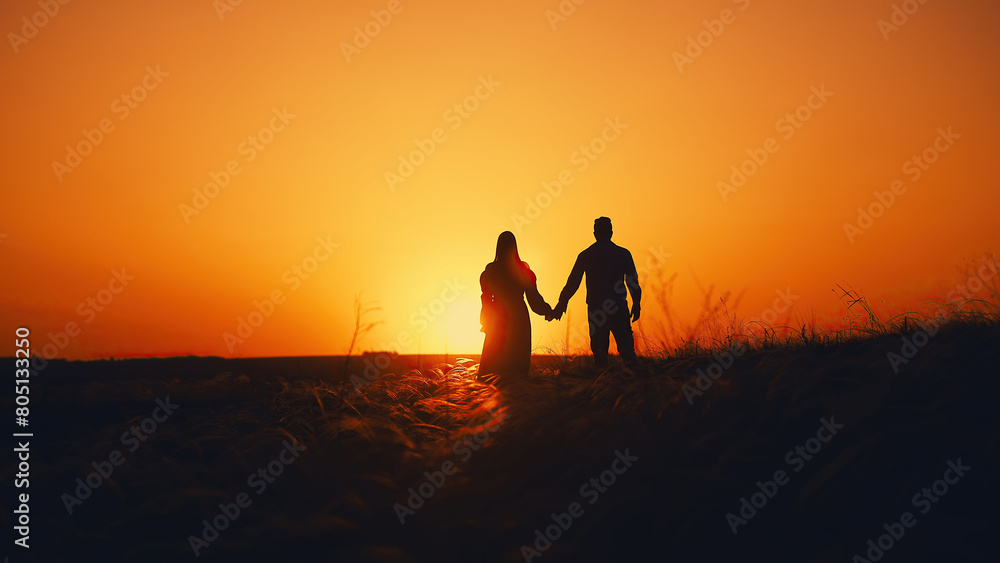 Couple in love in a field in the sunset sunshine. A beautiful romantic moment between two lovers walking through a field. Concept of love of two people, relationship and lifestyle.
