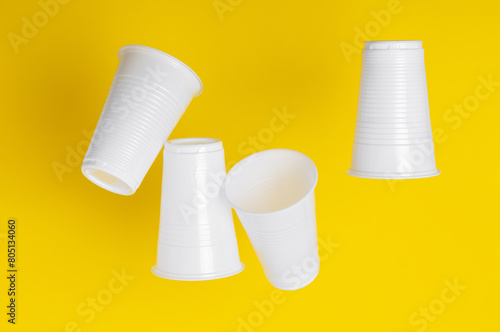 Disposable plastic cups closeup on a yellow background