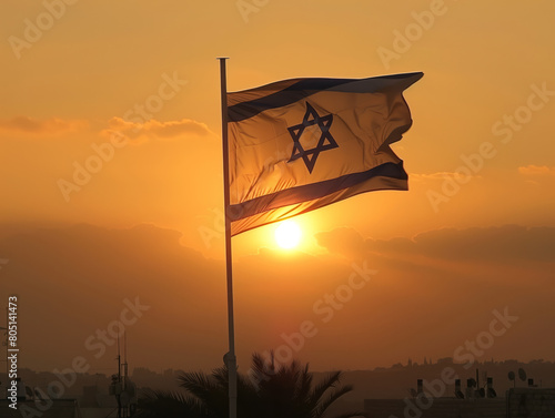 Photo of the Israeli flag flying against an orange sky at sunset, symbolizing freedom and independence in Israel. 