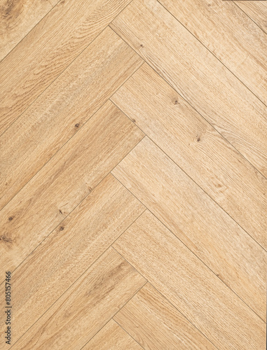 Geringbone pattern laminate in light brown with shades of beige, imitating the texture of natural wood.