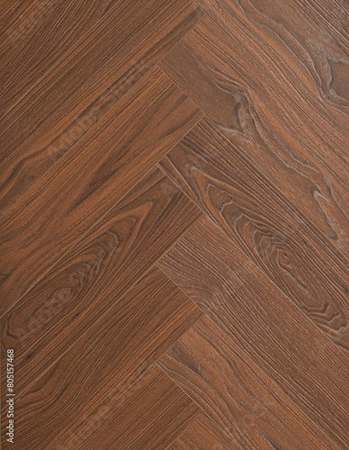 Dark brown laminate with imitation of natural wood grain. The fibers and patterns are visible, giving it a realistic and elegant look. The laminate is laid in a geringbone (fishtail) pattern, which ad