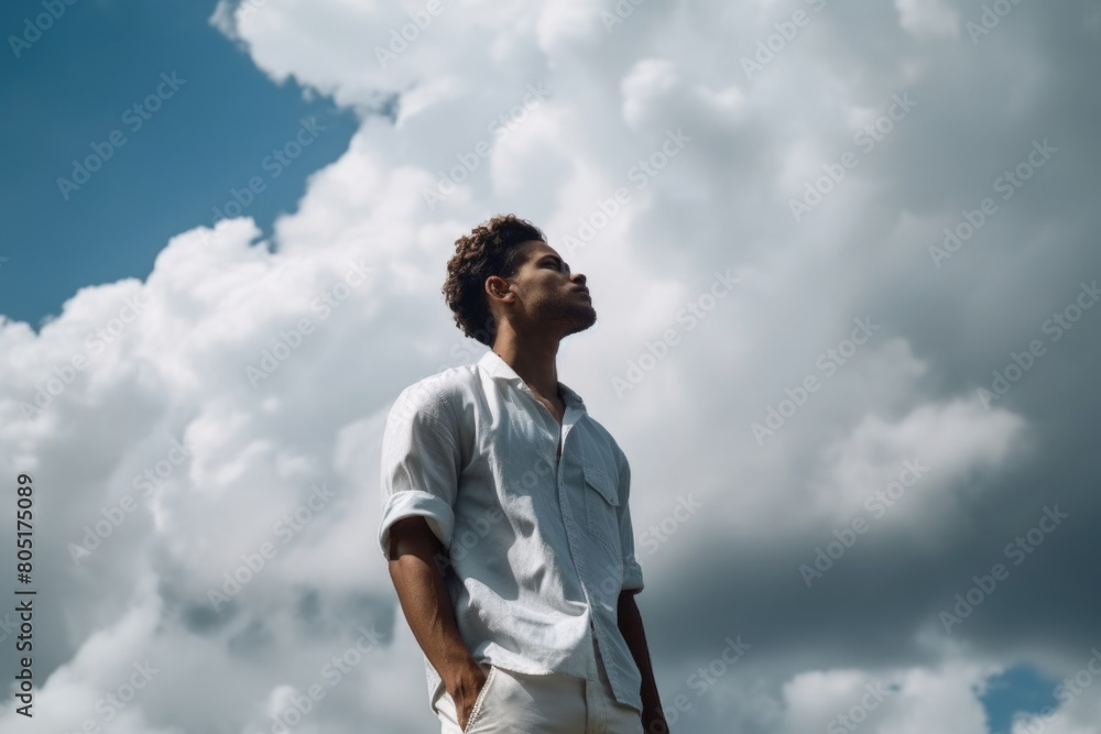 A man standing and looking up at the cloudy sky A man standing and looking up at the cloudy sky