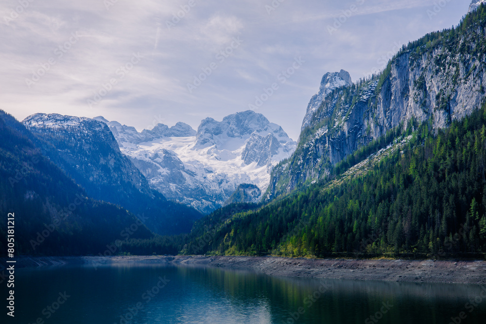 A magical morning atmosphere at a lake that is surrounded by alpine mountains.