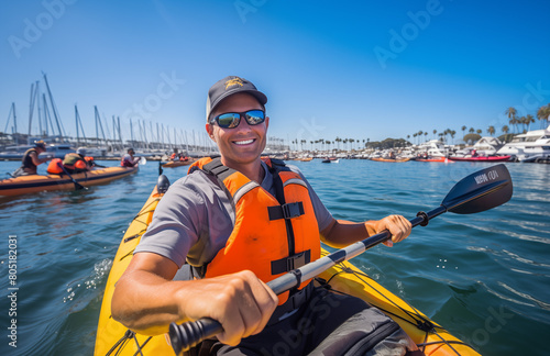 Contented bearded man in a life jacket rowing with oars on a boat and enjoying the beautiful scenery paddling