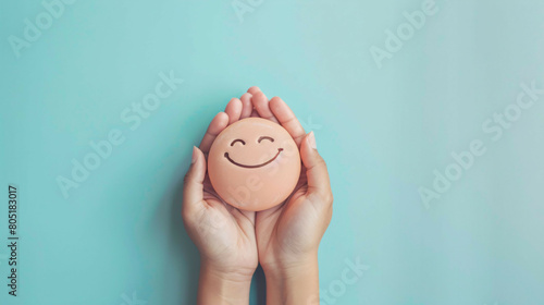 Harmony of Positive Emotions: Minimalist Hands Holding Smiley Face on Pastel Background photo