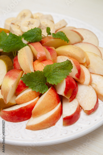 A plate of season cut fresh fruit. Fruit salad from apple, pear and banana. Diet, healthy fruit salad on plate - healthy breakfast, weight loss concept.