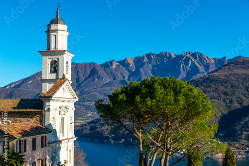 Church of Saints Fedele and Simone and Lake Lugano with Mountain in a Sunny Day in Vico Morcote, Ticino in Switzerland. photo