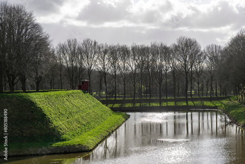 Grass overgrown rampart and canal around the village of Bourtange (former Fort Bourtange), near Westerwolde the Netherlands; fortress built in 1593 in shape of a star  photo