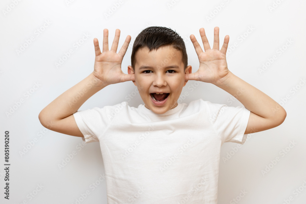 The guy raised his hands to his ears, shows a funny face. Sincere children's emotions. The guy raised his hands to his ears, shows a funny face. Sincere children's emotions.