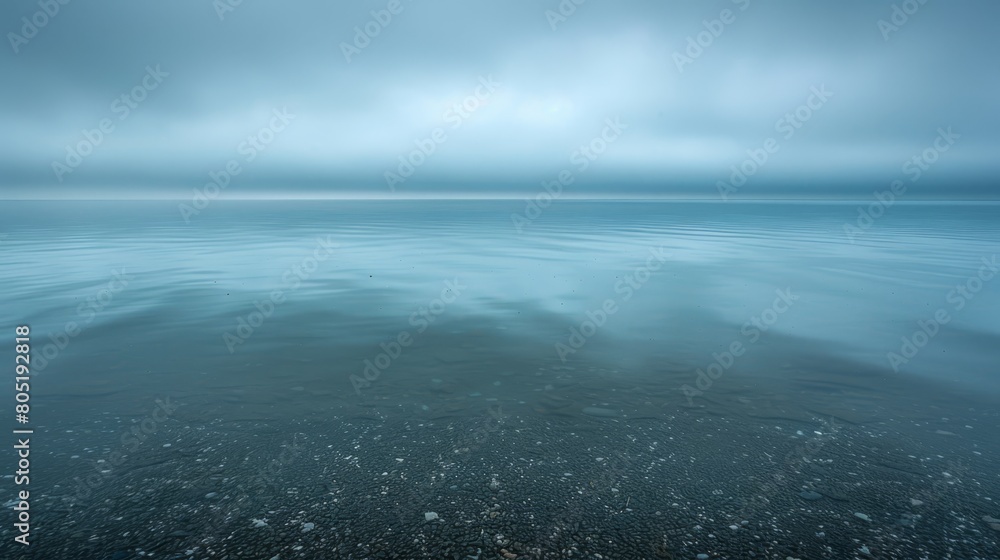 A vast expanse of water with a backdrop of cloud-speckled sky A vast expanse of water with a backdrop of cloud-speckled sky