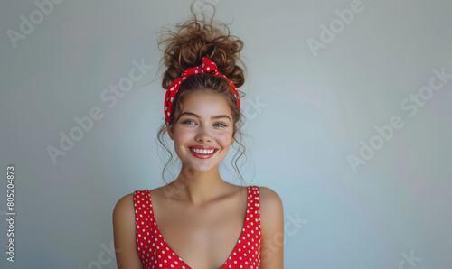 Happy Young pin-up woman in red swimsuit show winning on gray background photo