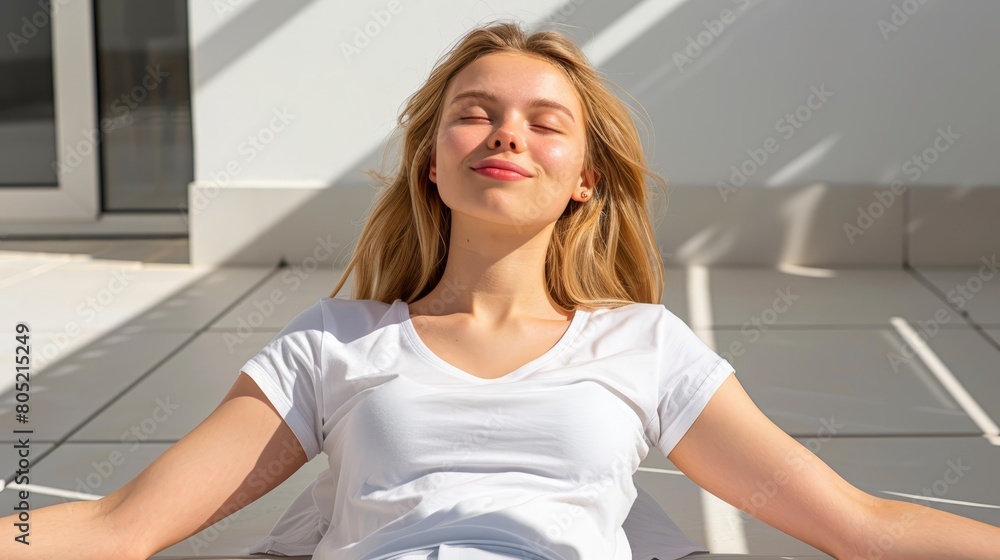 A woman in a white shirt sits with closed eyes in a yoga pose A woman in a white shirt sits with closed eyes in a yoga pose