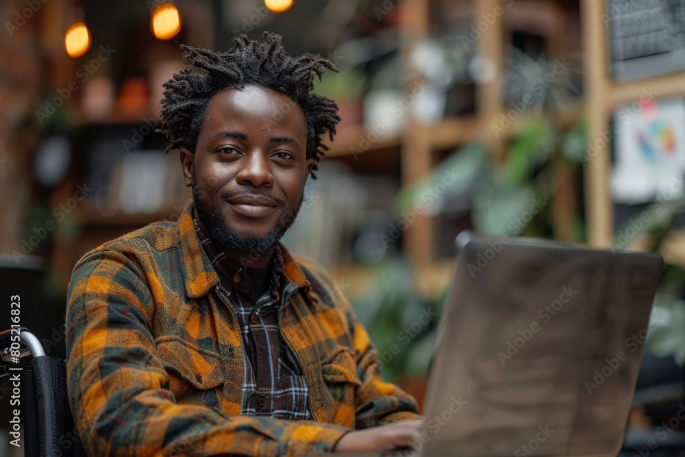 Obraz premium A young man in casual attire works on a laptop amid lush greenery in a bright greenhouse environment