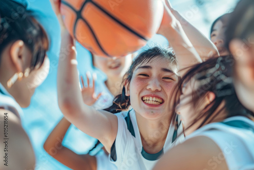 A group of female women are enjoying playing basketball happily and restlessly together on the basketball court. © Surachetsh