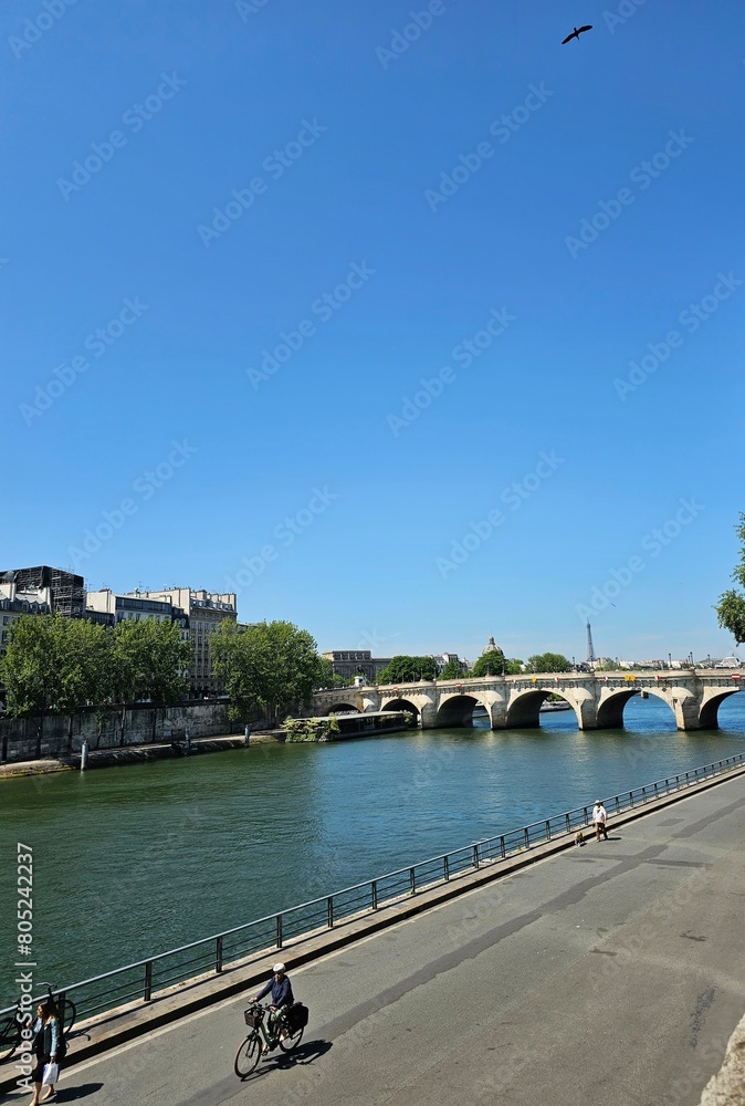 Strolling or Cycling on the River Bank of the Seine River in Paris during Summer with View of Eiffel Tower and Parisien Bridge