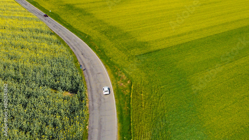 Aerial drone view of two cars driving along a country road, Spinetta Marengo, Piedmont, Italy photo