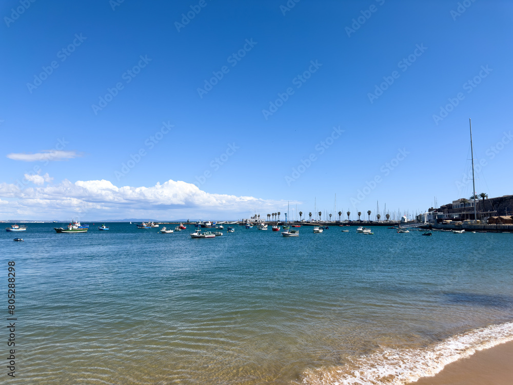 Calm beach with crystal clear water and boats in the background. Calm beach with crystal clear water and boats in the background.