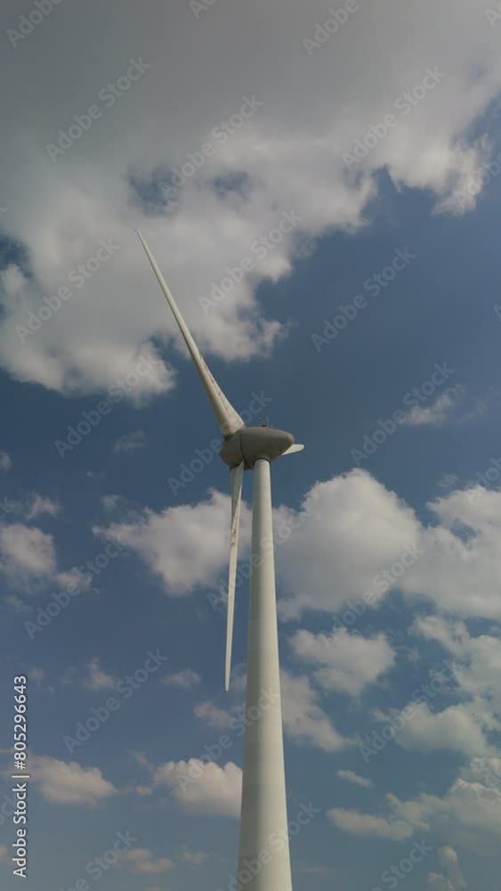 windmill turbine with clouds and a blue sky, windmill turbines generate green energy in the ocean. Energy transition in the Netherlands Europe